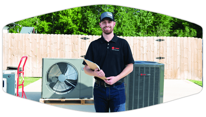 Technician standing in front of Trane units