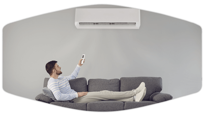 Guy lying on the couch turning on ductless unit