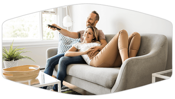 Couple relaxing in living room couch watching TV